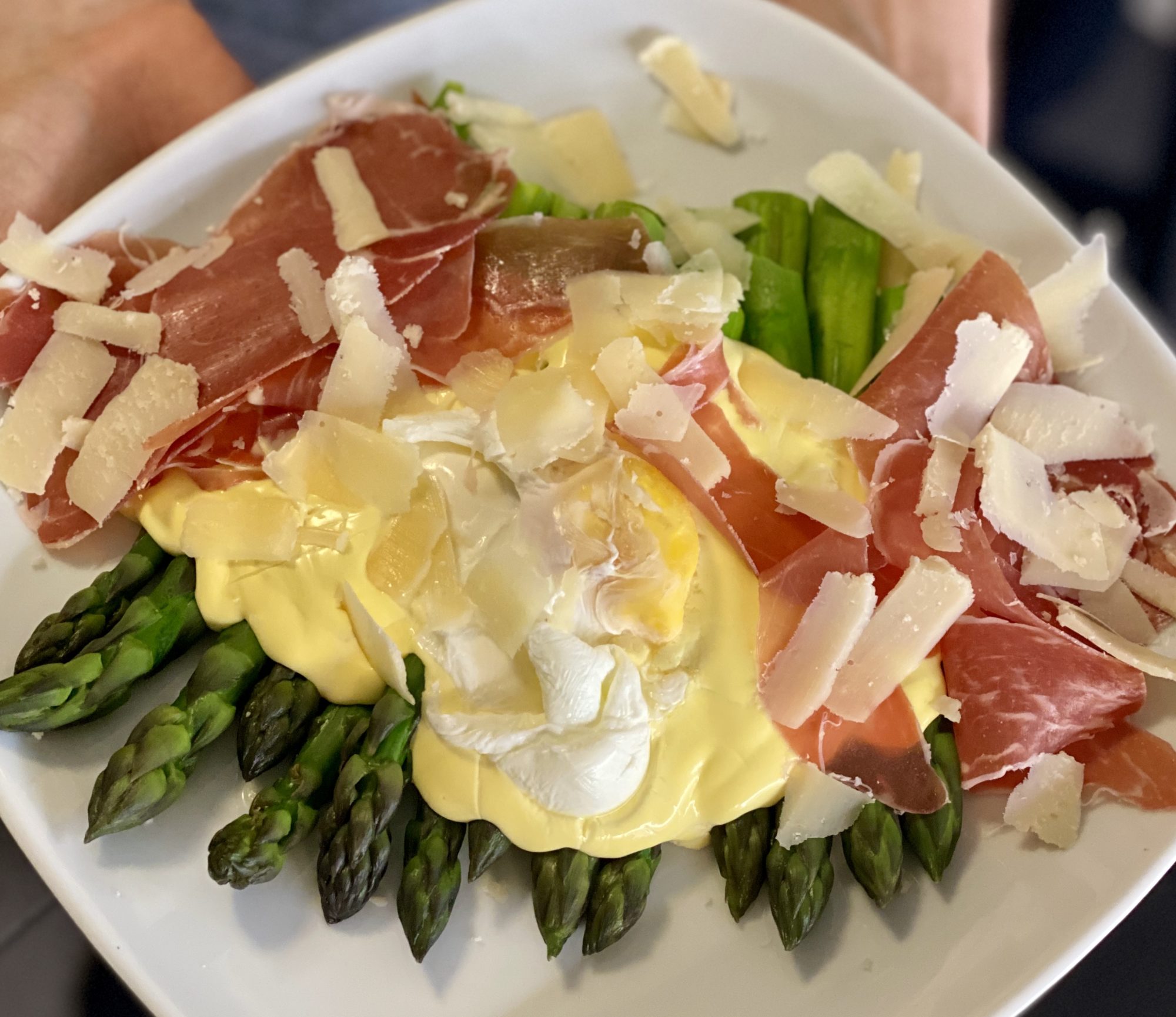 Parsaa hollandaise kastikkeella, uppomunalla, ilmakuivatullaa kinkulla ja parmesan juustolla
