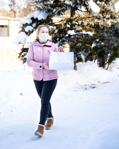 Yrittäjä toimittaa ruoan asiakkaan kotiin.